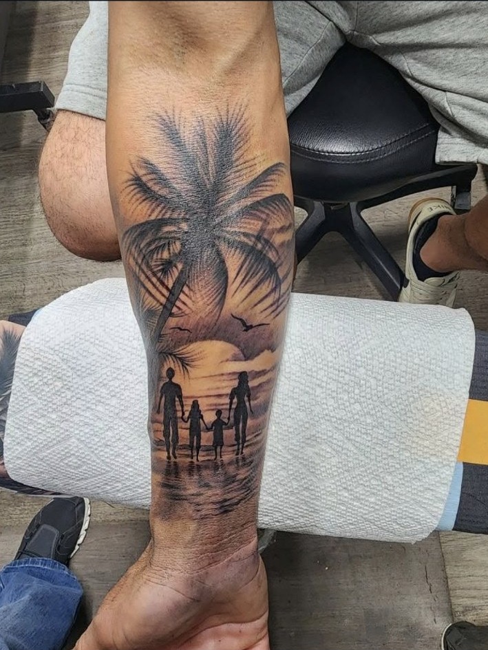 Black and grey palm tree and family sunset forearm tattoo by Miguel